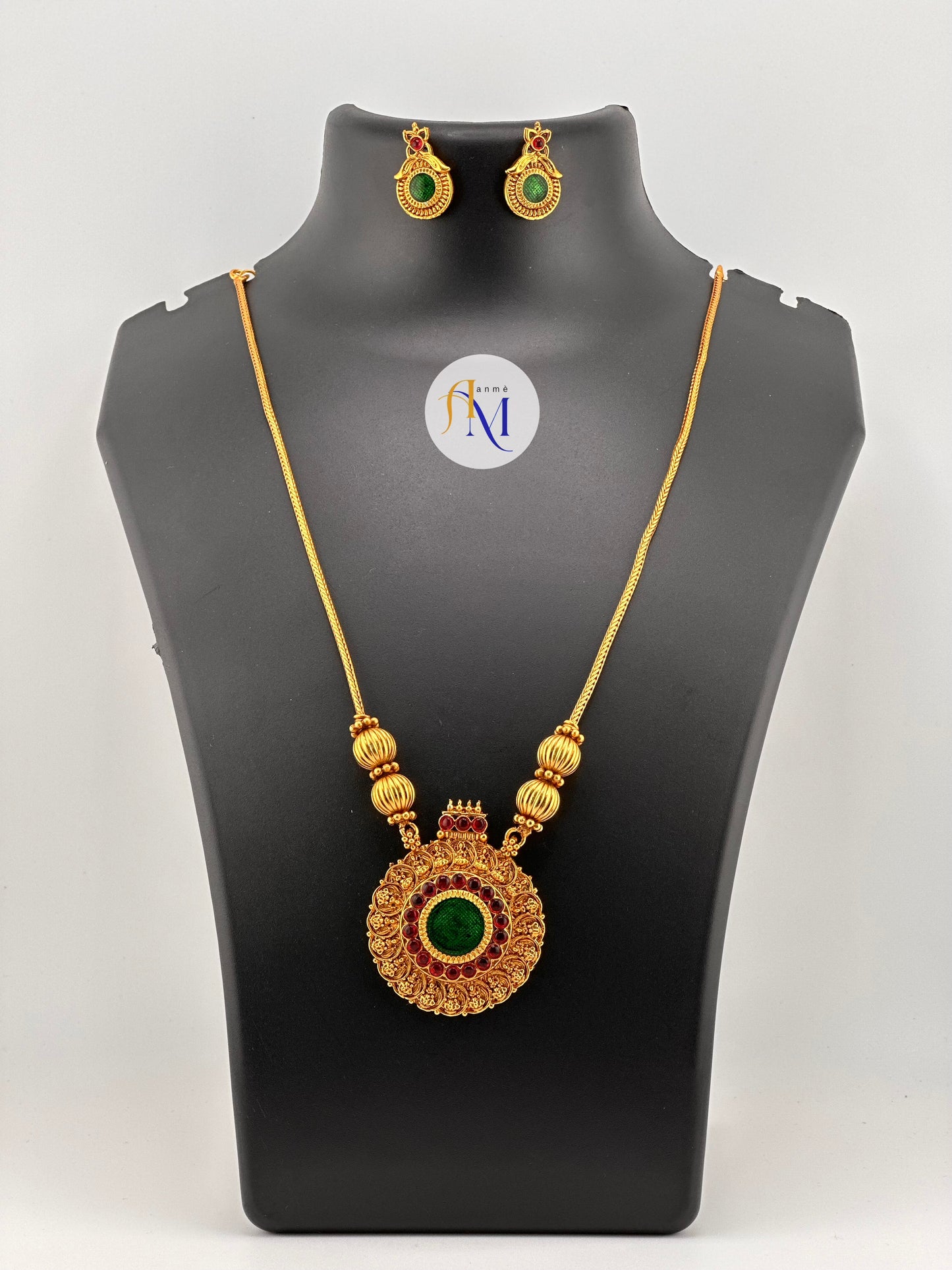 Beautiful round pendant with ruby-green stones and lakshmi motifs with simple chain and earrings
