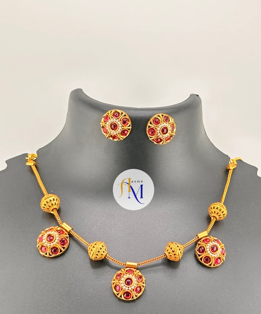 Traditional gold toned finish with ruby-green and white stones necklace set