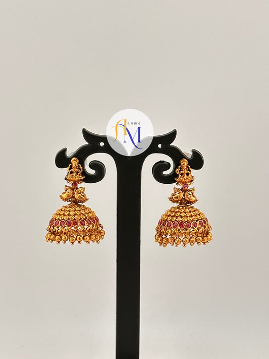 Simple temple design Jhumkas with Lakshmi, peacock and tiny floral motifs with ruby stones